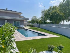 a swimming pool in a yard next to a house at Polinesia 5 in Lido delle Nazioni