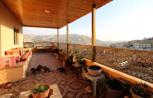 a balcony with tables and chairs and potted plants at Petra Bed & Breakfast in Wadi Musa