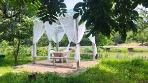 a white gazebo with a chair in a garden at Billina Private Boutique Garden Cottage in Huairou