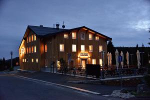 Horská chata Smědava في Weissbach: مبنى خشبي كبير مع إضاءة