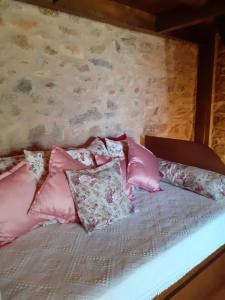 Una cama con almohadas rosas encima. en Casa do Terreto & Casa do Forno en Parada