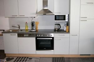 a kitchen with white cabinets and a stove top oven at Sellraintaler Auszeit 1 in Sellrain