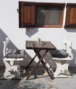 een picknicktafel en twee stoelen naast een gebouw bij Casa do Terreto & Casa do Forno in Parada
