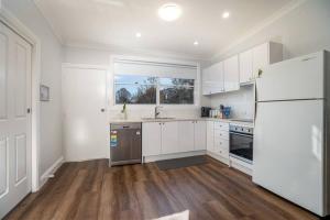 a kitchen with white cabinets and a white refrigerator at Paddington Villa 2 - wi-fi, Netflix in Orange