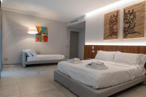 a bedroom with a large bed and a couch at Villa D'Orville luxury suites Taormina in Taormina