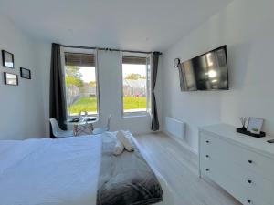 1 dormitorio blanco con 1 cama, vestidor y ventana en Onyx d'Opale, en Calais