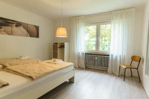 a white bedroom with a bed and a window at Großzügiges Apartment mit Balkon für Monteure und Feriengäste in Pachten