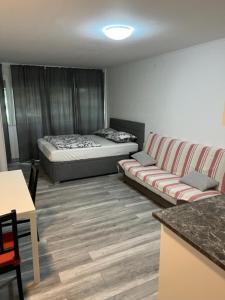 a room with a bed and a couch and a table at Apartman Utrine 1 in Zagreb