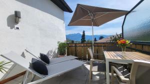 a patio with a table and chairs and an umbrella at Fruemess - Historic Refugium in Parcines