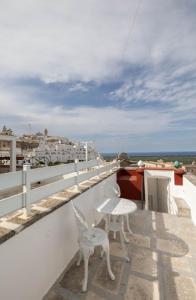a balcony with a chair and a table on a roof at Dimora Antelmi - Tra Cielo & Mare in Ostuni