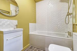 a bathroom with a tub and a sink and a mirror at Opulent Abode - Stunning One-Bedroom Flat - Southend Stays in Southend-on-Sea