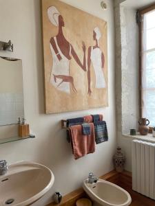 a bathroom with a sink and a tub and a painting at Ferme de Maillezais in LʼHoumeau