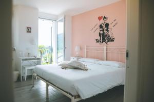 a bedroom with a large bed with a pink wall at B&B il Cappellaio di Erika in Brovello-Carpugnino