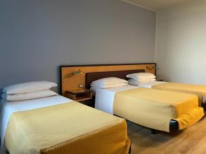 een kamer met drie bedden in een kamer bij Art & Hotel Treviolo in Treviolo