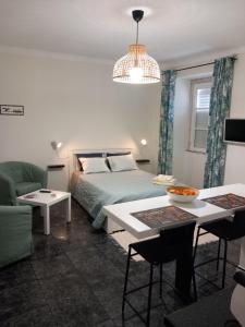 ein Schlafzimmer mit einem Bett, einem Sofa und einem Tisch in der Unterkunft Casa Porta do Sol in Estremoz