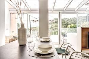 ein Esszimmer mit einem Tisch mit Vase und Stühlen in der Unterkunft Suite La Panoramica in Massa Lubrense