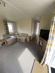 a living room with a couch and a television at Impeccable 3 bedroom lodge pet friendly in Northampton