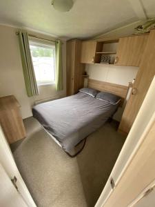 a bedroom with a bed in a small room at Impeccable 3 bedroom lodge pet friendly in Northampton