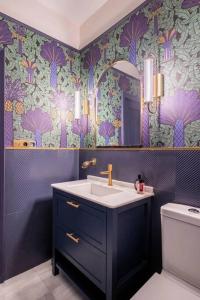 baño con lavabo y pared púrpura en Designer Apartment en Sevilla