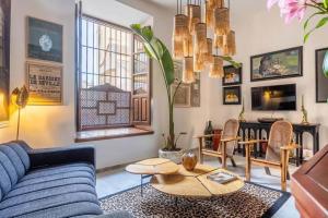 sala de estar con sofá azul y mesa en Designer Apartment en Sevilla