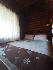 een bed in een kamer met een raam en een deken bij Chalet's lake_Bolu Abant _log house in Piroğlu