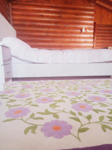 een slaapkamer met een bed met een bloemrijk tapijt bij Chalet's lake_Bolu Abant _log house in Piroğlu