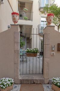 une porte menant à un bâtiment avec deux vases sur lui dans l'établissement Villa D'Orville luxury suites Taormina, à Taormine