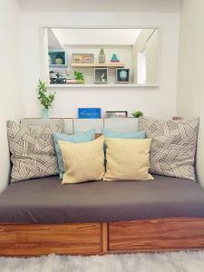 a couch with pillows on it in a room at Scandinavian Room at Wind Residences in Tagaytay