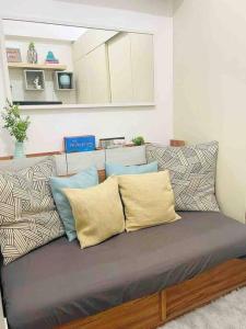 um sofá com almofadas num quarto em Scandinavian Room at Wind Residences em Tagaytay