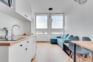 奧波萊的住宿－Serce Opola Katowicka 39，厨房以及带蓝色沙发的客厅。