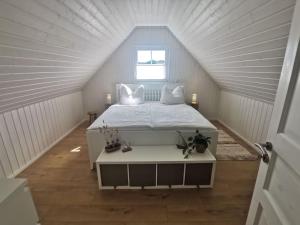 a bedroom with a white bed in a attic at Hafenhaus Panoramablick mit Sauna & Whirlpool in Wandlitz +32 photos