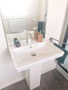 lavabo blanco en el baño con espejo en Hafenhaus Panoramablick mit Sauna & Whirlpool, en Wandlitz