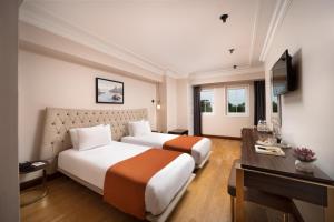 a hotel room with two beds and a television at Recital Park Hotel in Istanbul