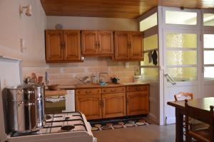 a kitchen with wooden cabinets and a stove at les gites du passage: la popote in Passenans