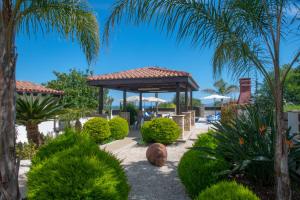 a garden with a gazebo and palm trees at Kallizoni villa in Paphos City