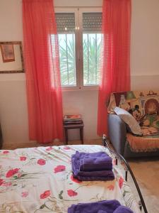 a bedroom with a bed and a window with red curtains at Lovely 1 bedroom attached apartment with kitchen but private with seasonable pool in Albox