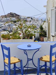a table and two chairs on a balcony with a view at Neo-Traditional Sunrise Apartment in Ios Chora