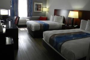 um quarto de hotel com duas camas e uma secretária em Travelodge Inn & Suites by Wyndham Albany em Albany