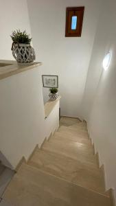 a hallway with stairs with a plant on the wall at Casa Vacanze MarGiu Pater Domus in Goriano Sicoli