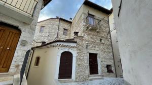 un gran edificio de piedra con una ventana lateral. en Casa Vacanze MarGiu, en Goriano Sicoli