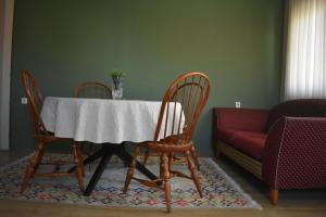 a dining room table with four chairs and a couch at MANEVI Apartment in Strumica