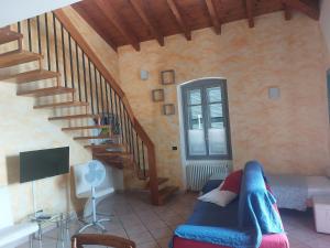 a living room with a couch and a staircase at Foresteria Hostaria Del Golfo cod struttura C00025 in Laveno-Mombello