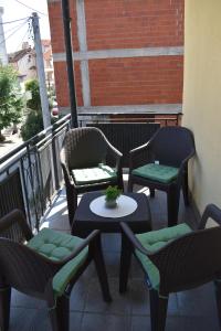 3 sillas y mesa en un balcón con mesa en MANEVI Apartment, en Strumica