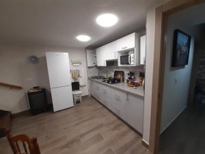a kitchen with white cabinets and a white refrigerator at Casa de tía Patricia in Montemayor del Río