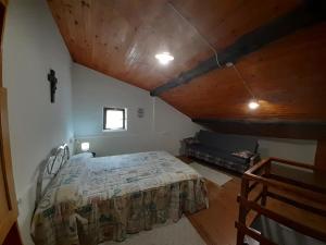 a bedroom with a bed and a wooden ceiling at Casa de tía Patricia in Montemayor del Río