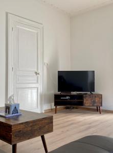 sala de estar con TV de pantalla plana y mesa de centro en Appartement Le lion, en Belfort