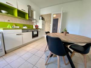 cocina con mesa de madera y sillas en Appartement Le lion, en Belfort
