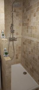 een badkamer met een douche en een wit bad bij La Bohème in Eyragues