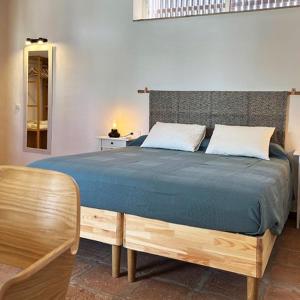 1 dormitorio con 1 cama grande con manta azul en El Patio de las Minas, en Aznalcázar