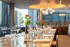 a long table with wine glasses and a flower on it at Hilton London Wembley in London